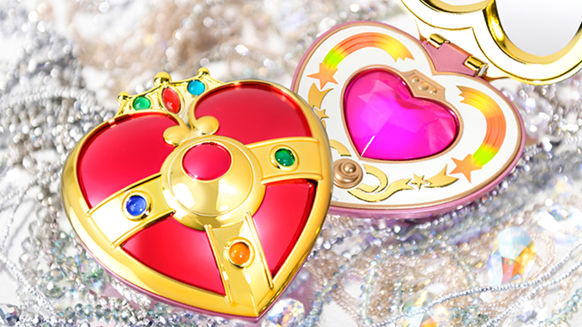Two Sailor Moon Cosmic Heart Compact Proplica transformation brooches with one open and one closed.