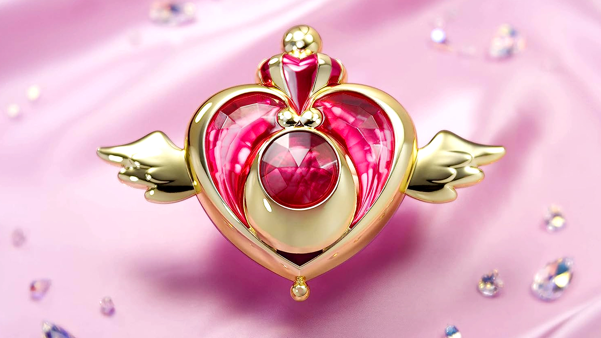 Sailor Moon Eternal Crisis Moon Compact Proplica on a pink fabric with crystals and gems.