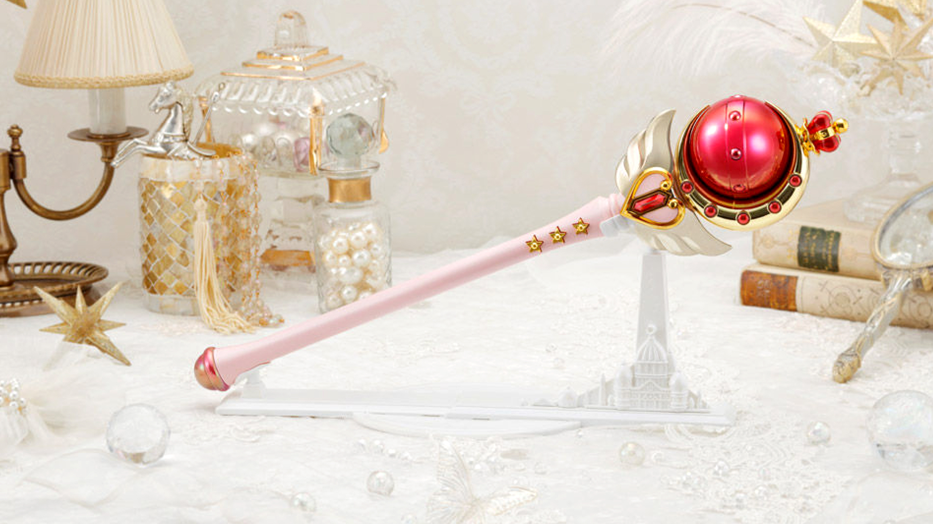 Sailor Moon Cutie Moon Rod Moon Sceptre Brilliant Color Edition Proplica on white background with pearls and antique books.
