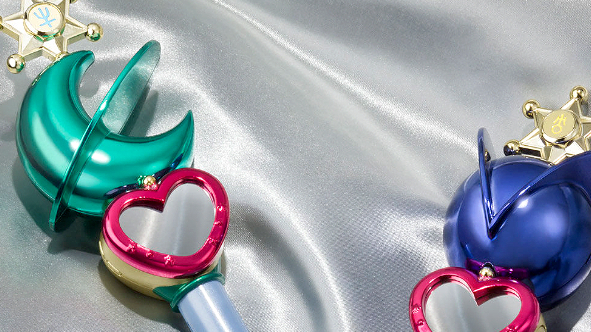 Sailor Uranus & Neptune Lip Rod (Transformation Stick) Proplicas lying on a silver sheet of fabric.